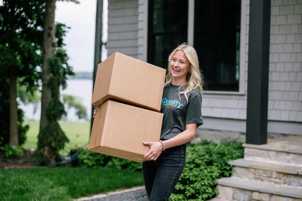 Team member carrying boxes to a Twin Cities home